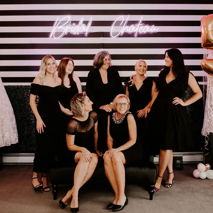 7 members of the Bridal Chateau Team, smiling at each other and wearing all black.