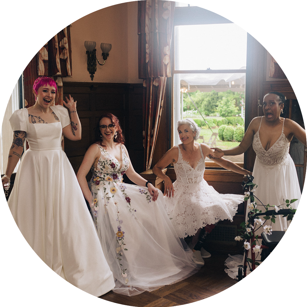 Group of four models wearing wedding dresses and laughing: Danica, Shelby Lynn, Sue, and Sally. Different disabilities and races represented.