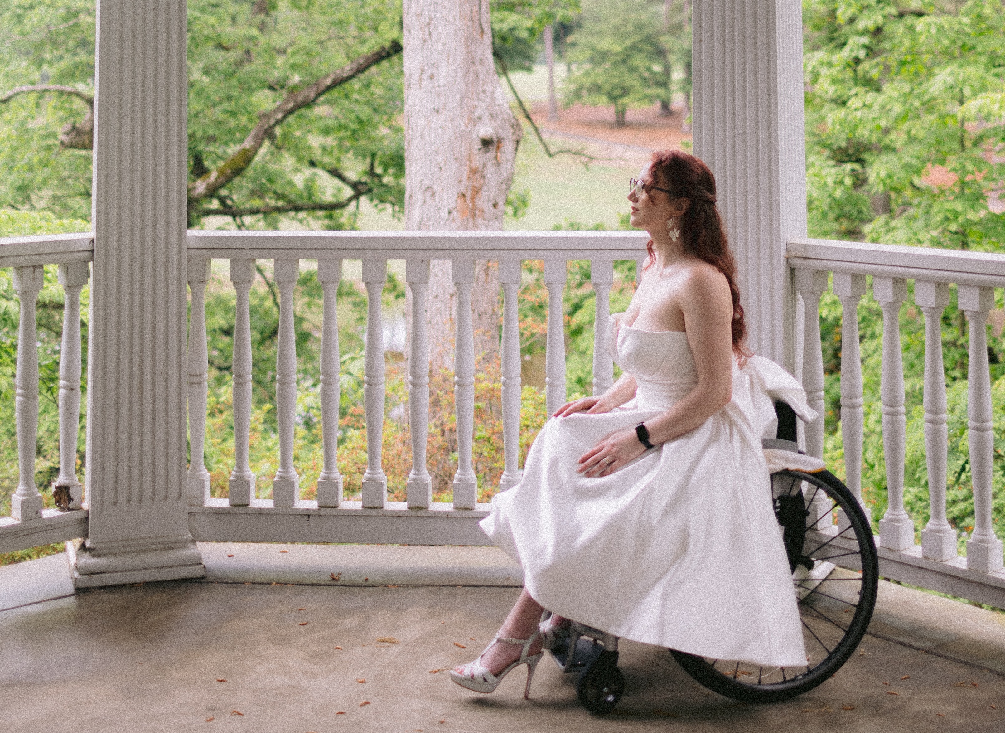 Photo of Shelby Lynn, a white person with long curly red hair wearing glasses in a short wedding dress, looking off towards the text. Text reads: "All Bodies, All Brides Certified Stores: We celebrate these boutiques, venues, and stores for completing our ABAB Certification Training, representing the highest standard of customized accessibility in the bridal industry! By completing this training, these businesses have learned about disability history, prepared to talk about disability correctly, determined how to adapt to access need requests, and embraces accessibility as a business tenant. We encourage you to shop with them, refer friends to them, and ask your local retailers to become certified!